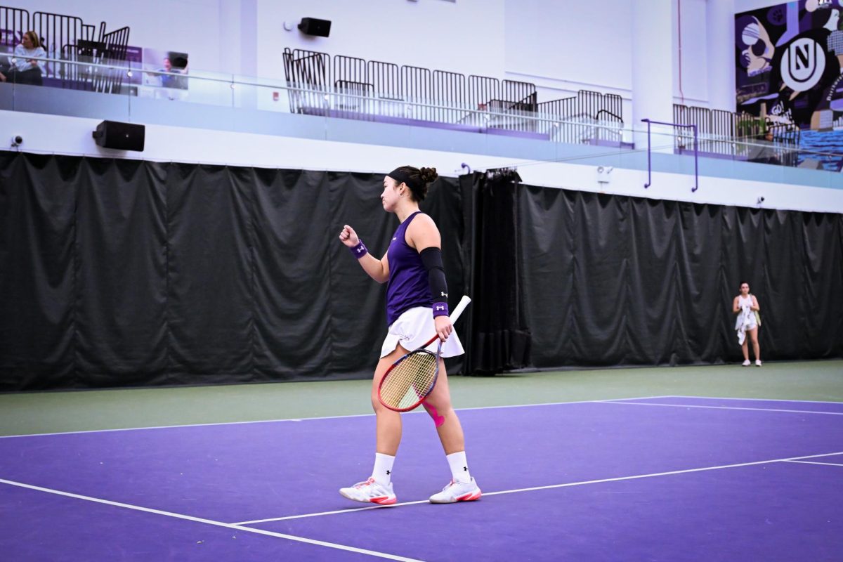 A tennis player pumps their fist while looking away.