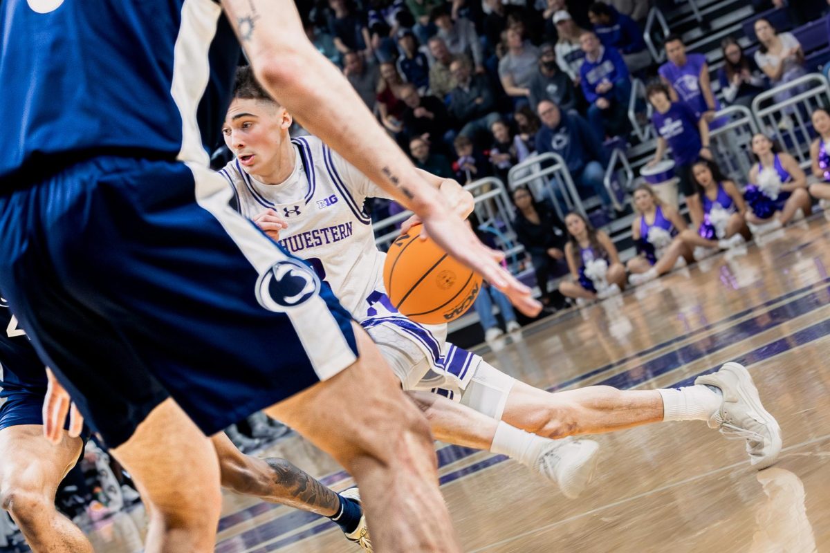 A Northwestern basketball player dribbles past a defender.