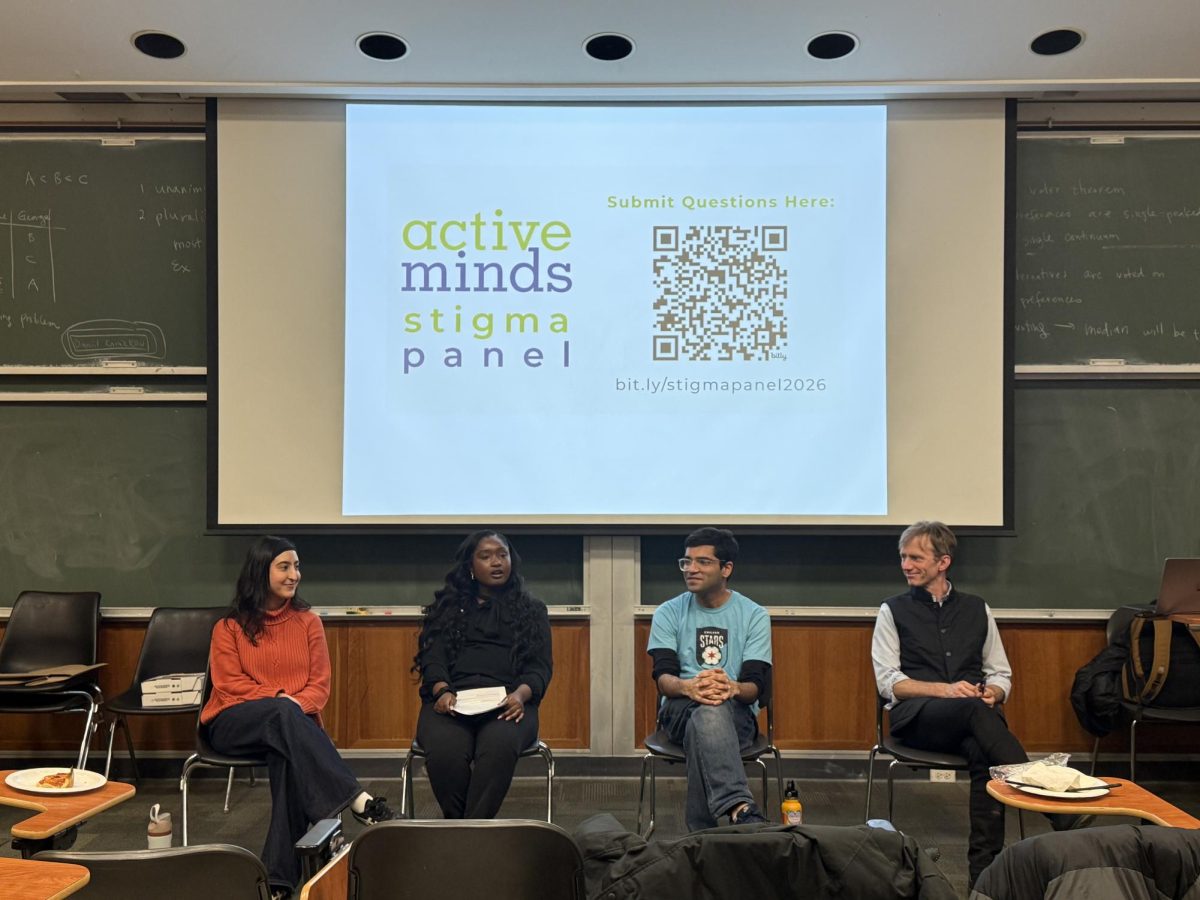 Panelists sit in front of a projected slideshow in a classroom.