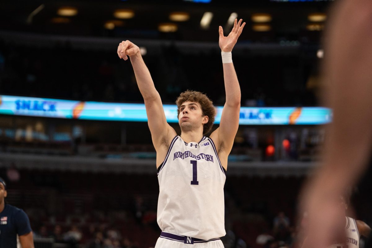 A basketball player in a white jersey follows through on his shooting motion after a shot.