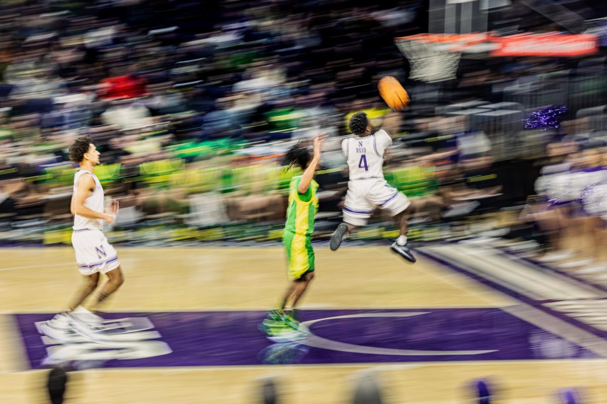 A Northwestern player jumps up for a layup while the background is completely blurred out.