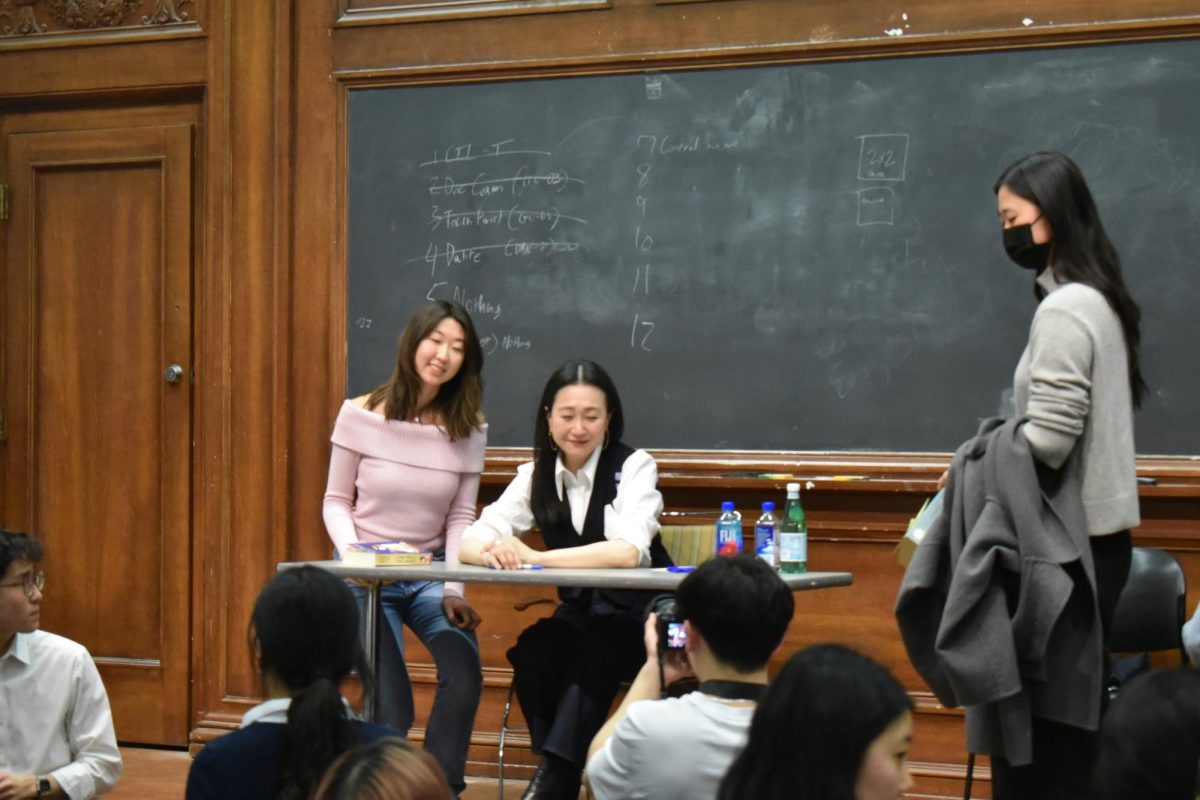 A person at a table takes a picture with someone.