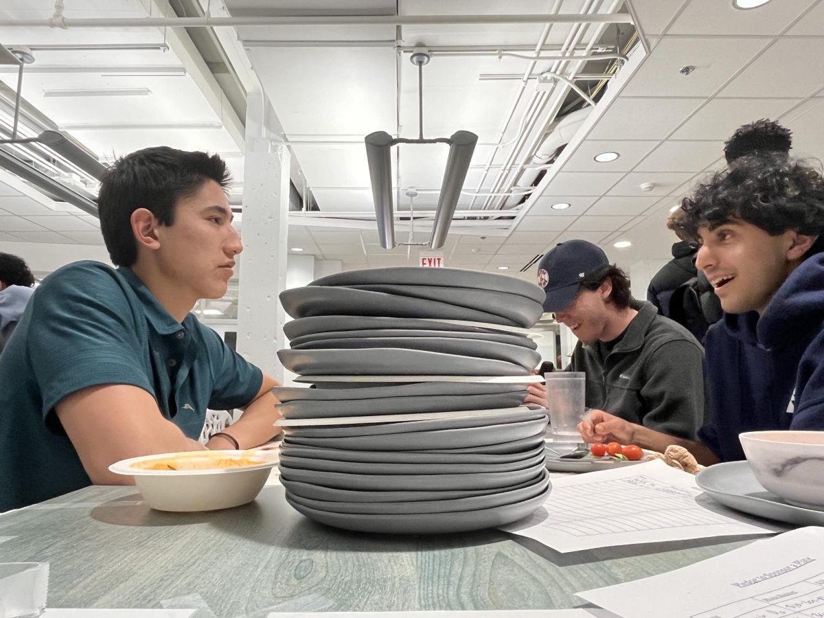 Stack of plates sit between two students.