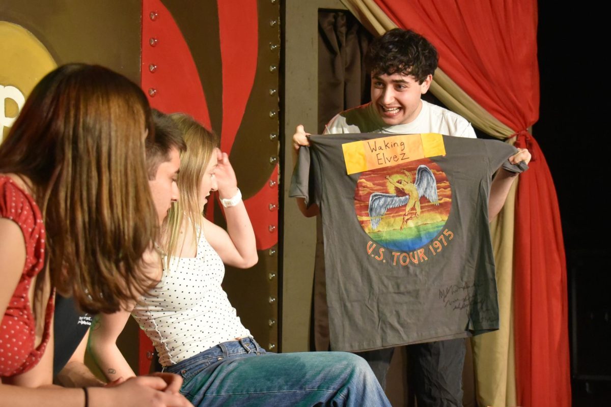 A performer displays a T-shirt to other people.