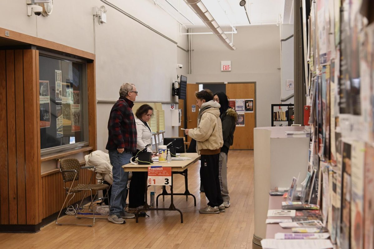 Voters checked in with poll workers before casting their votes at Noyes Cultural Arts Center.