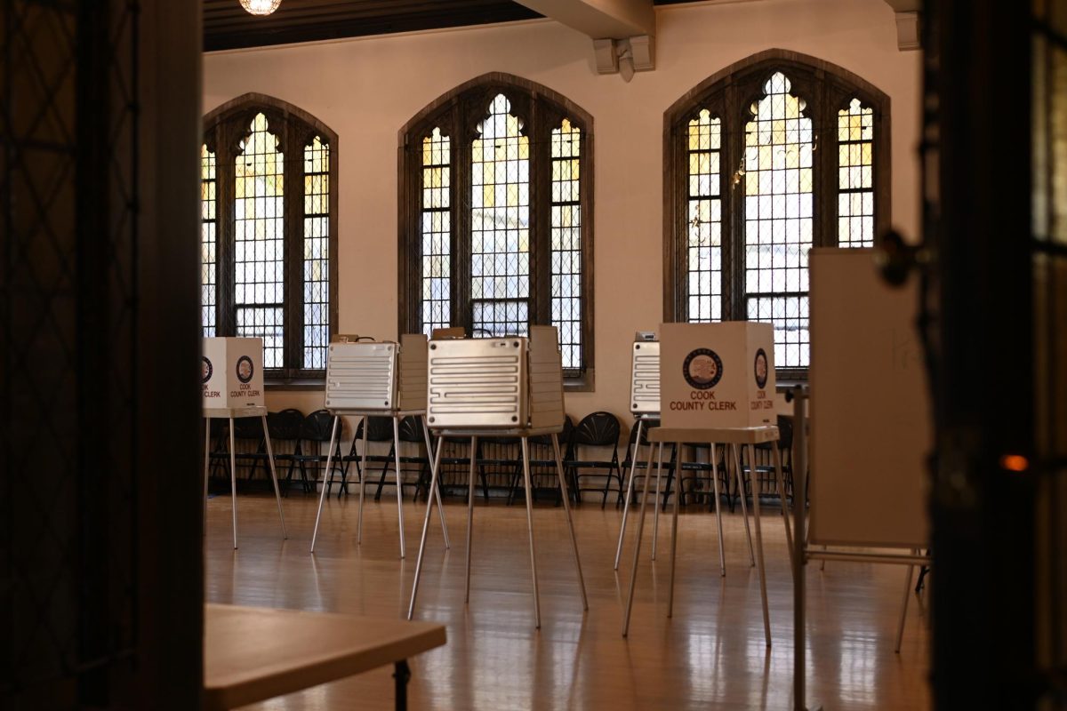 Just beyond open doors, voting booths reading &ldquo;COOK COUNTY CLERK&rdquo; are set up in lines.