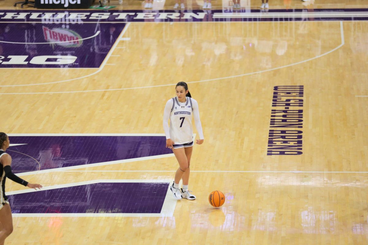 A person in a white jersey dribbles a basketball with nobody around.