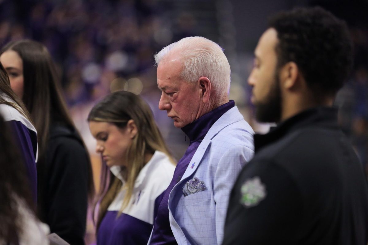 A person in a purple suit looks down.