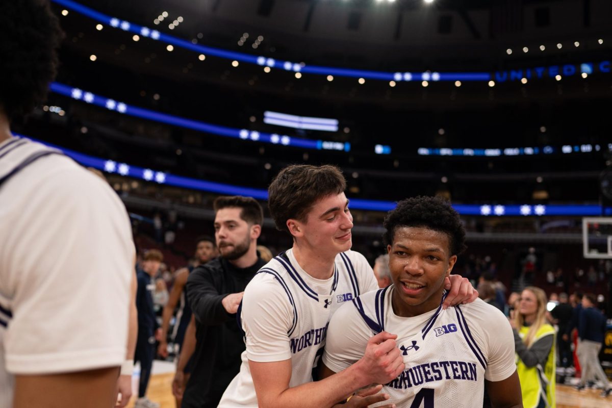 Two players in white jerseys celebrate after a win. 