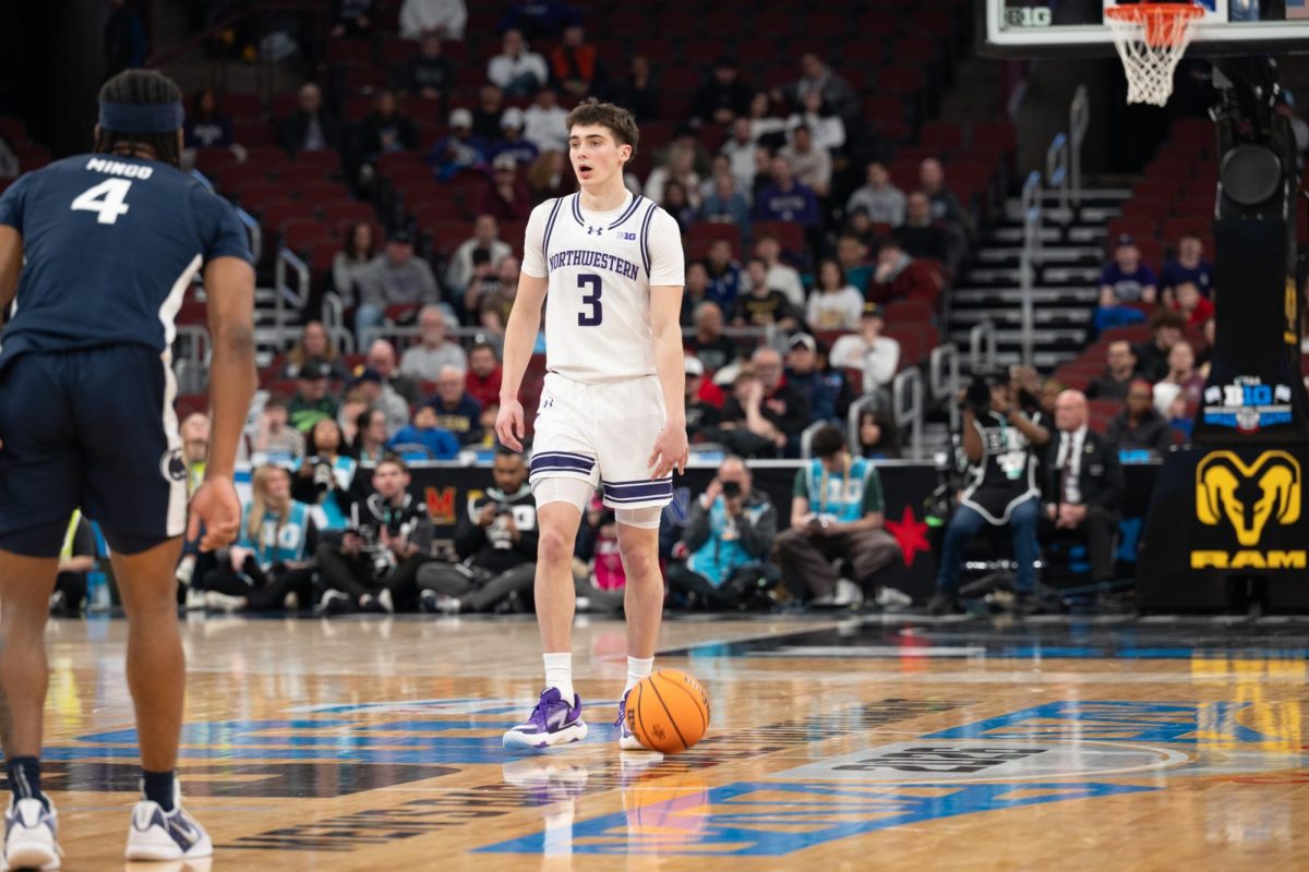 A player in a white jersey dribbles the ball down the court.