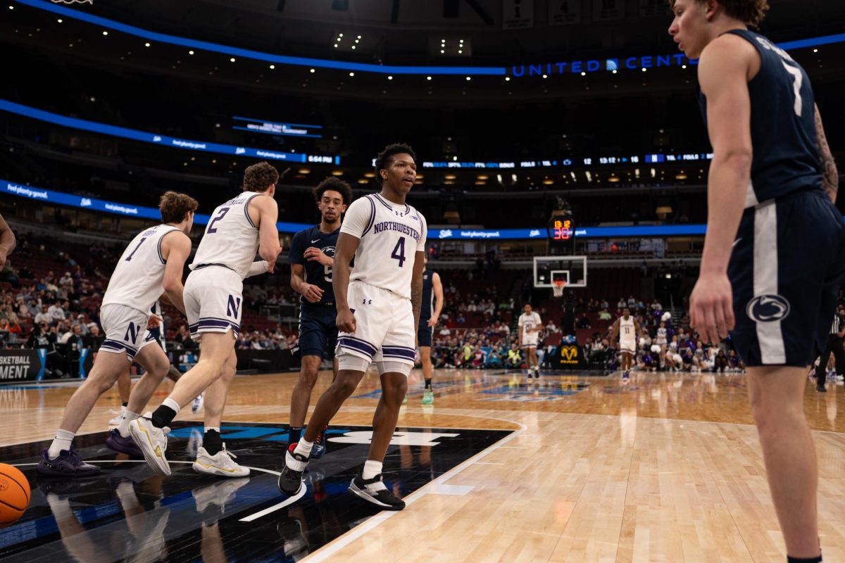 A player in a white jersey stares down an opponent. 