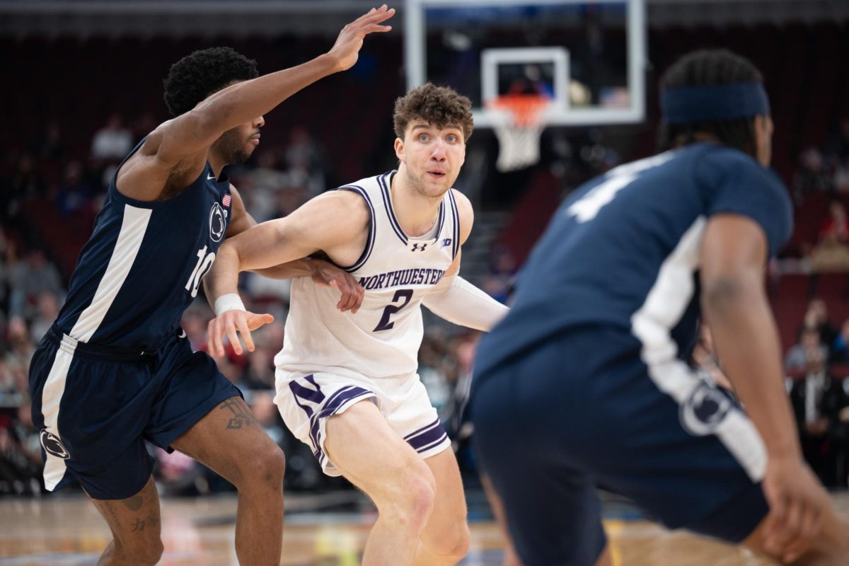 A player in a white jersey looks for an open teammate to pass to.