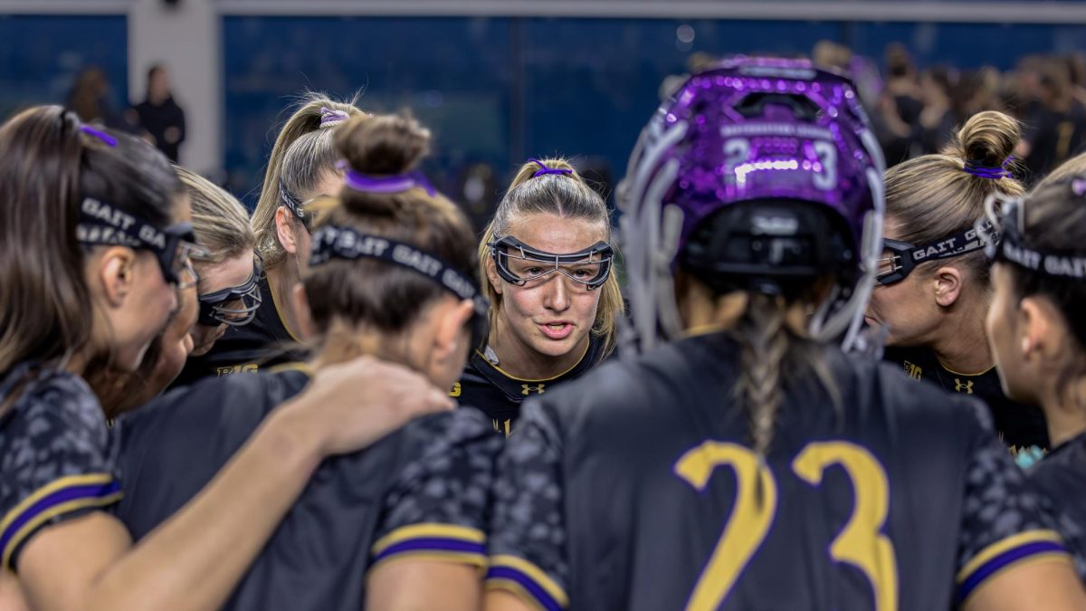 A Northwestern player speaks to their teammates in a huddle.