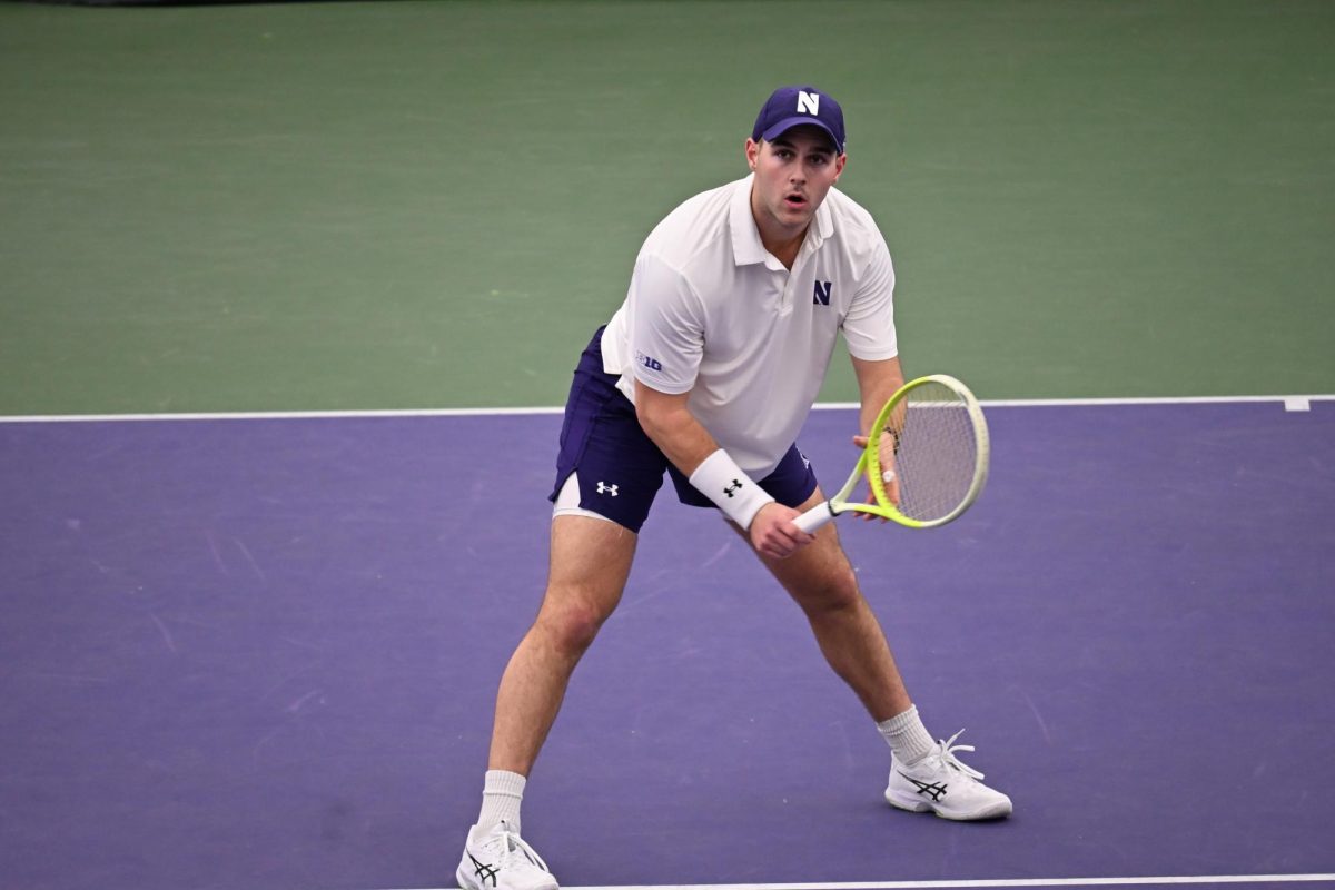 A person in a white shirt and shorts holds a tennis racket.