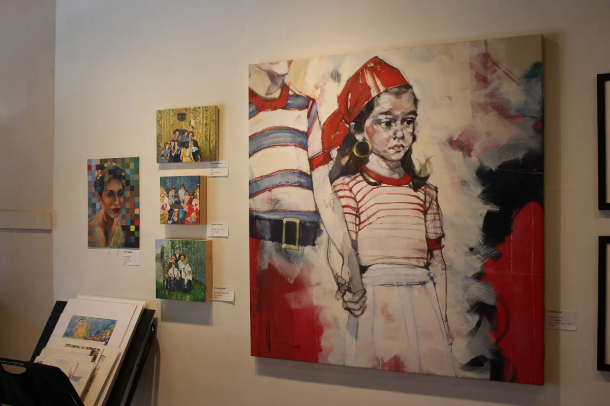 A large red and white painting of a person with four smaller, colorful paintings on the wall to the left of it.