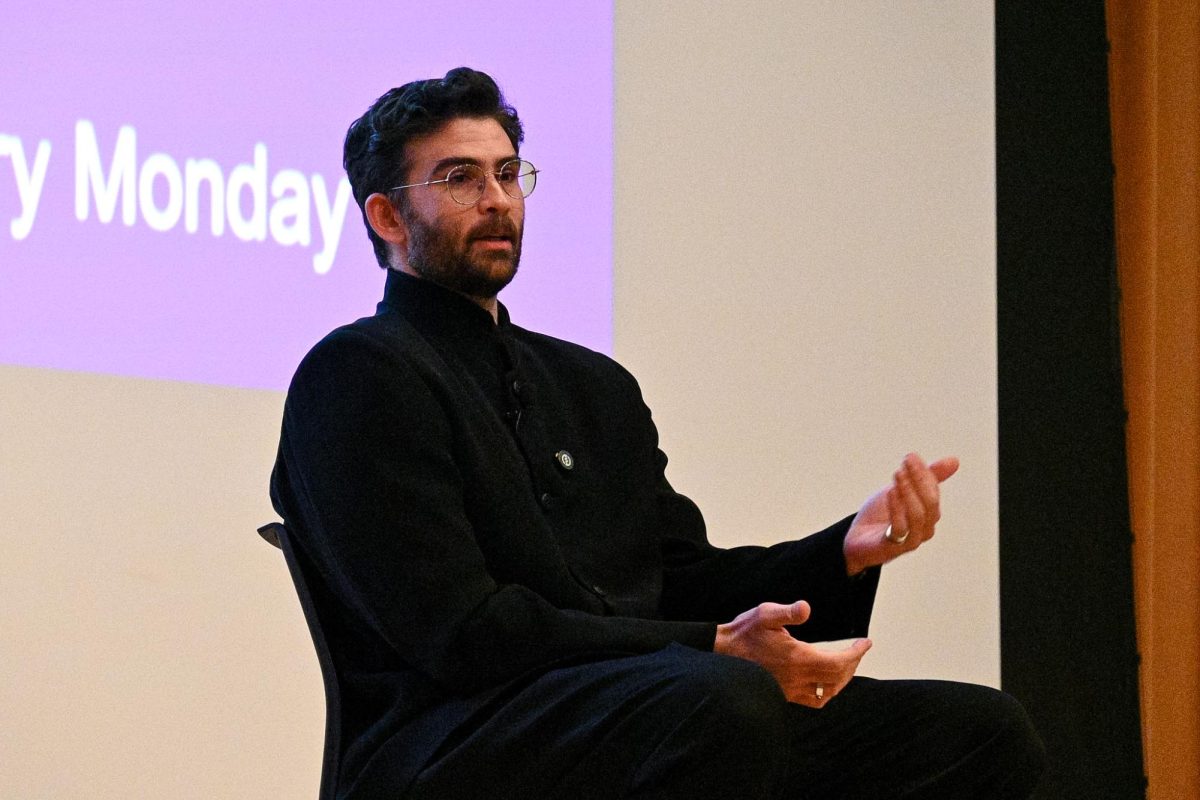 A person talks while sitting in a chair.