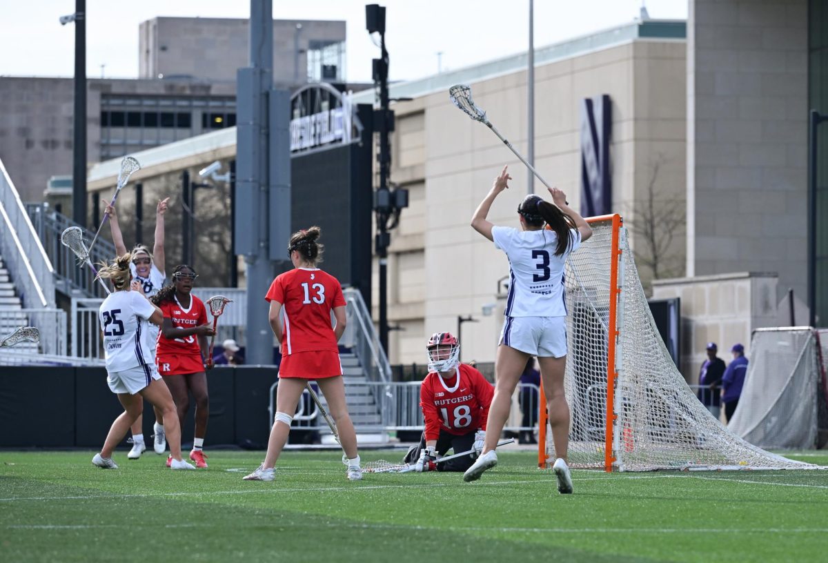 Players in white jerseys celebrate after a goal.