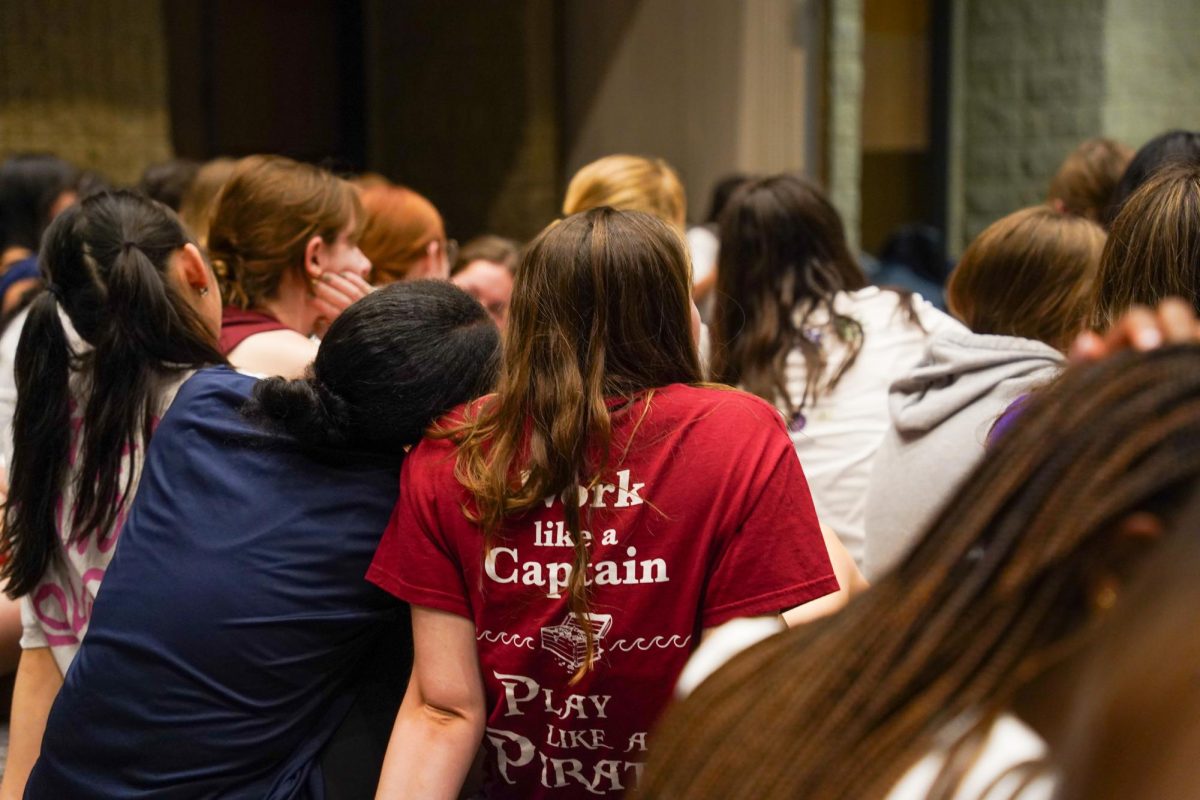 Girl lays her head on another girl's shoulder.