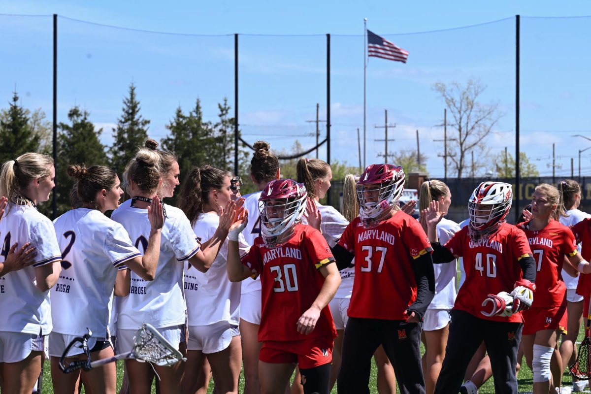 A line of players in white high-five players in red.