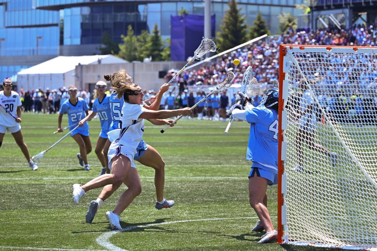A player in white shoots toward the goal.