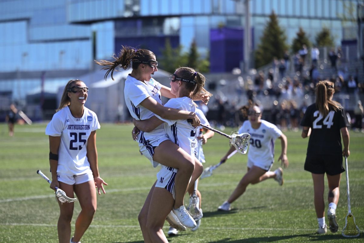 Lacrosse players jump into a hug. 