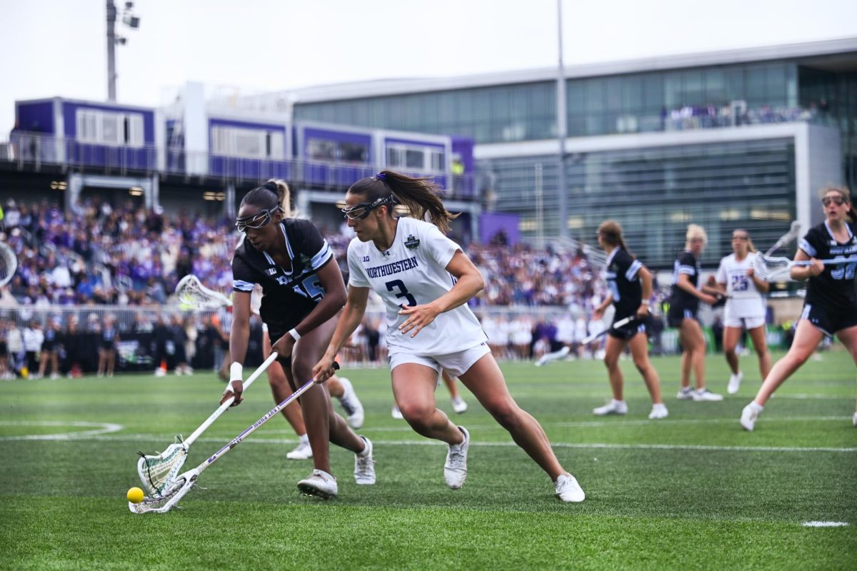 A player in white and a player in black chase down a ground ball.