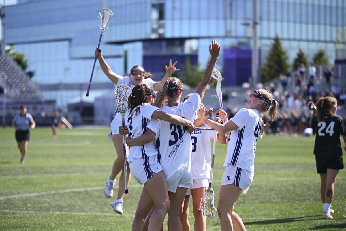 Players in white jerseys huddle together in celebration.