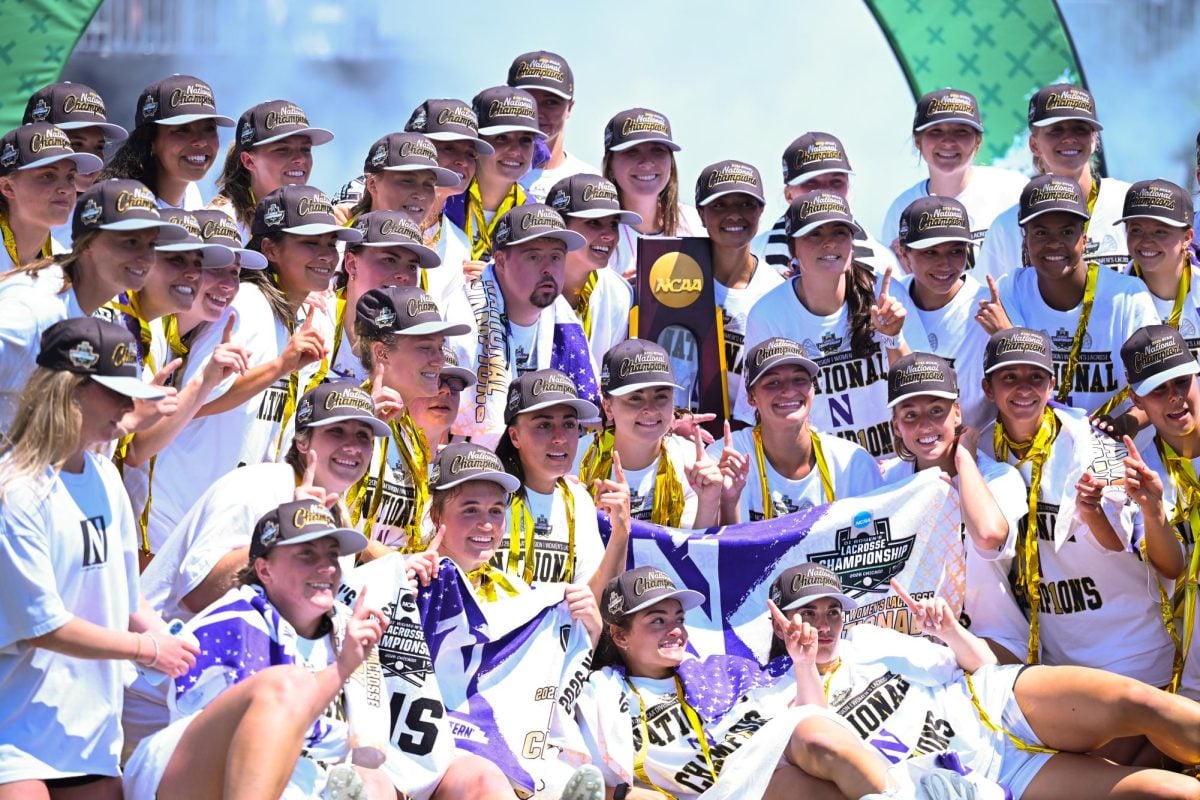 Players in white shirts smile with a trophy.