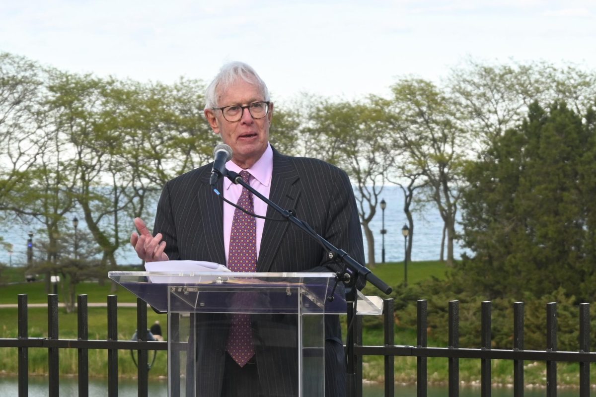 A person standing at a podium speaks into a microphone.