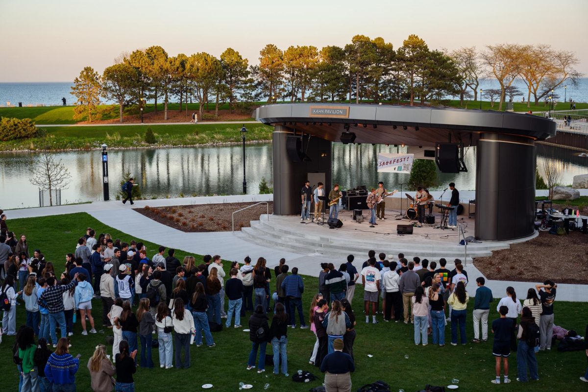  Crowd stands in front of a stage in front of the Lakefill.