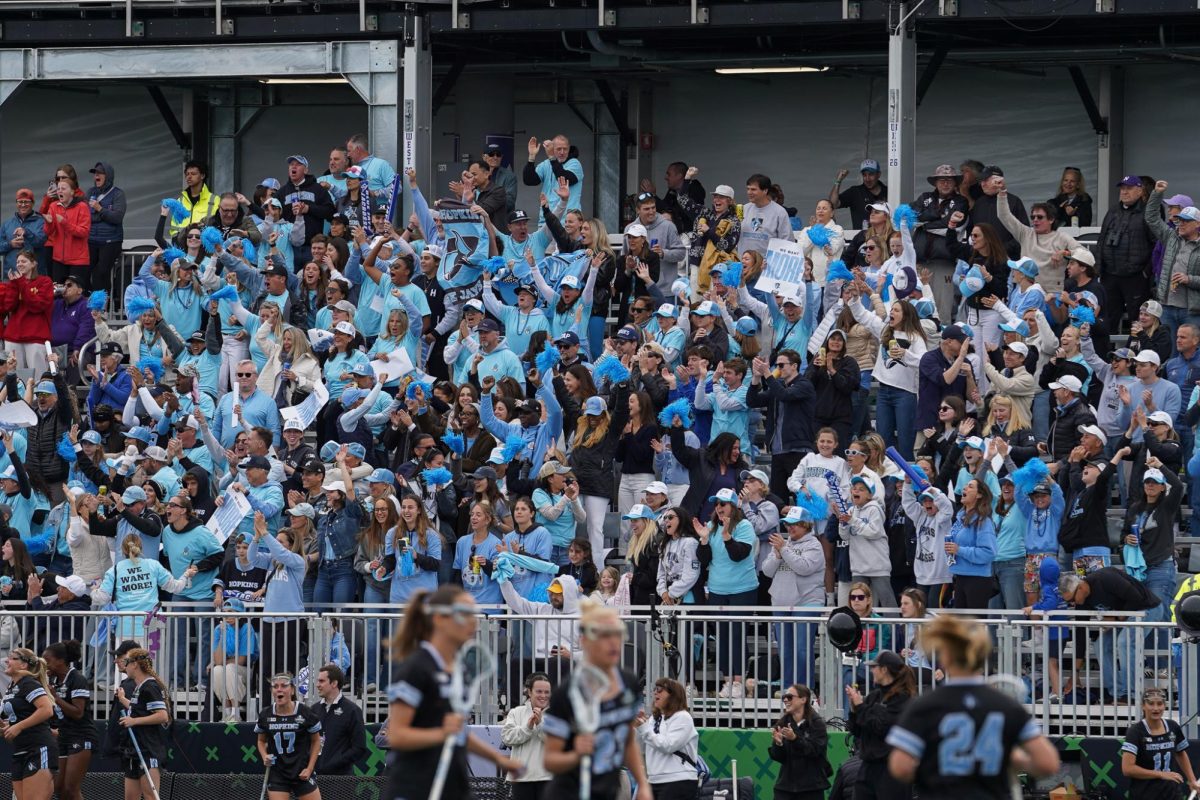 Fans wearing blue celebrate in the stands.