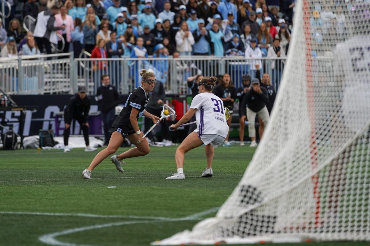 Players in black and white fight for a ball near the goal.