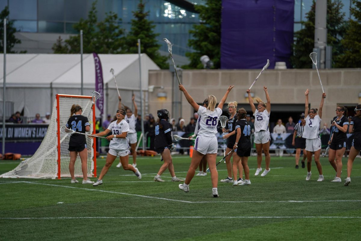 Players in white celebrate after a goal.