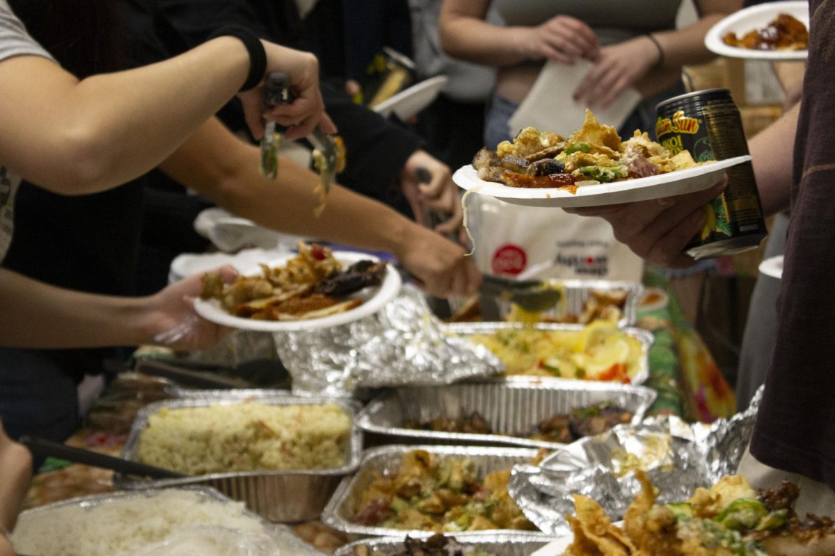 A person picks up food from a tray with tongs.
