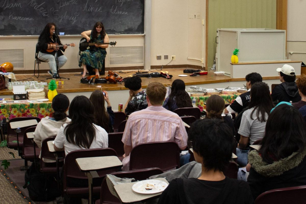 The audience watches performers play music on a stage.