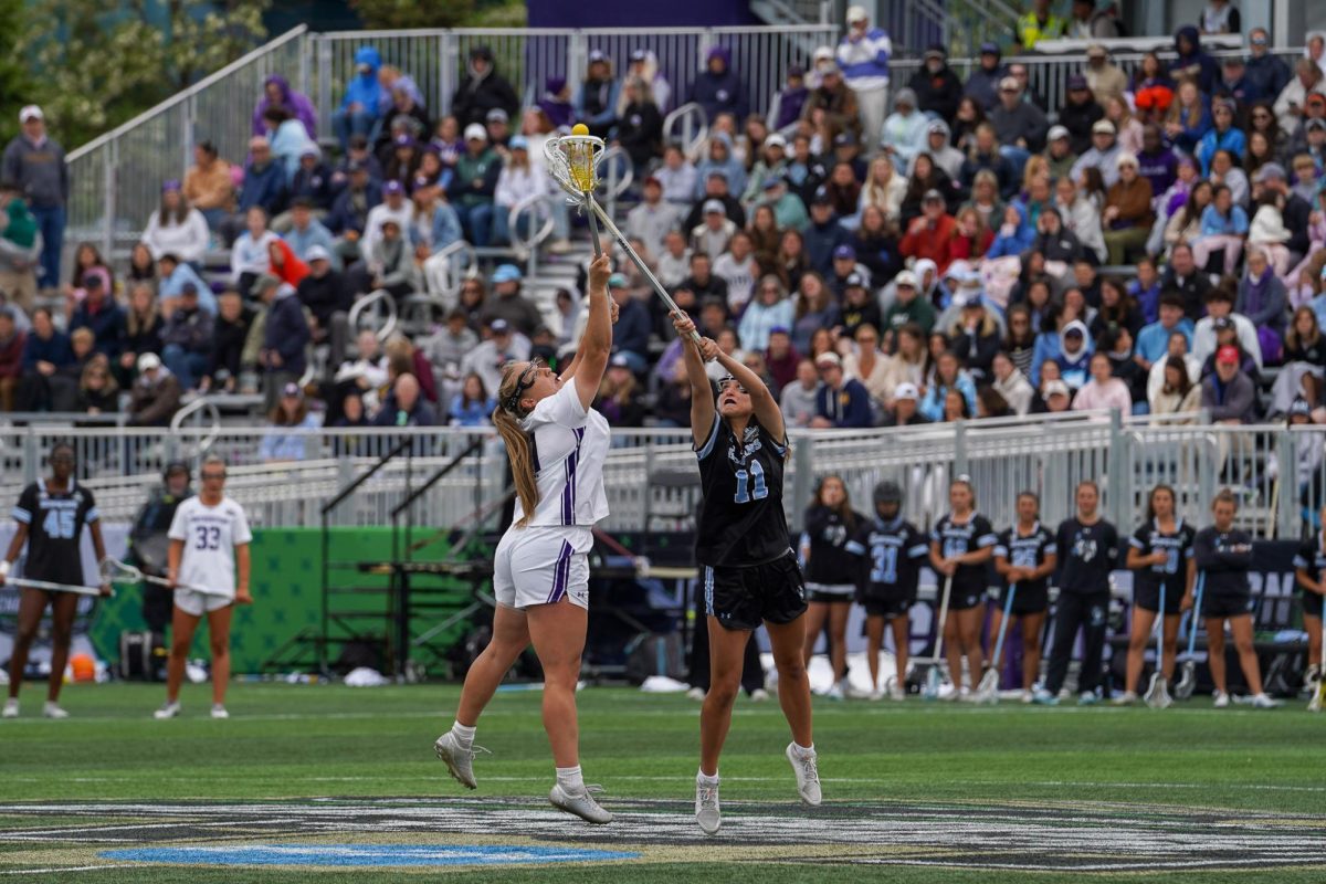 Players in black and white fight to catch a ball in the air.
