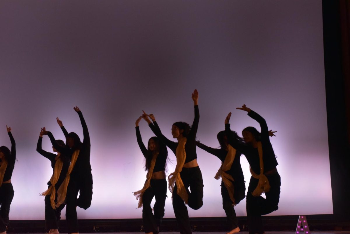 A group of dancers with their arms raised