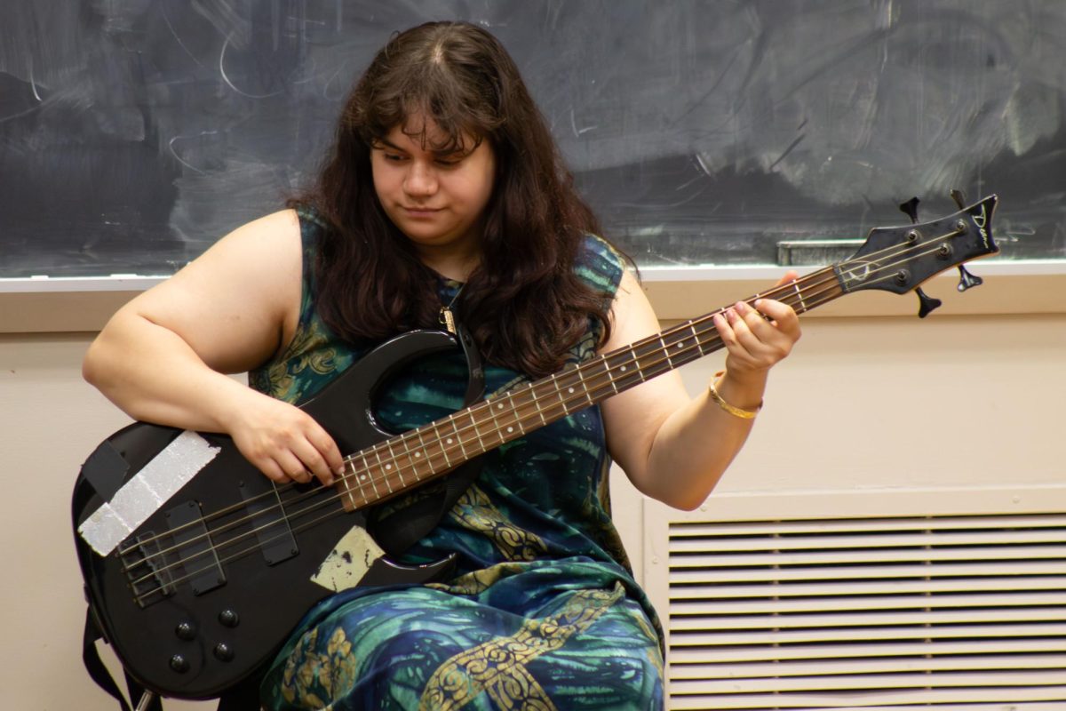 A performer plays guitar on stage.