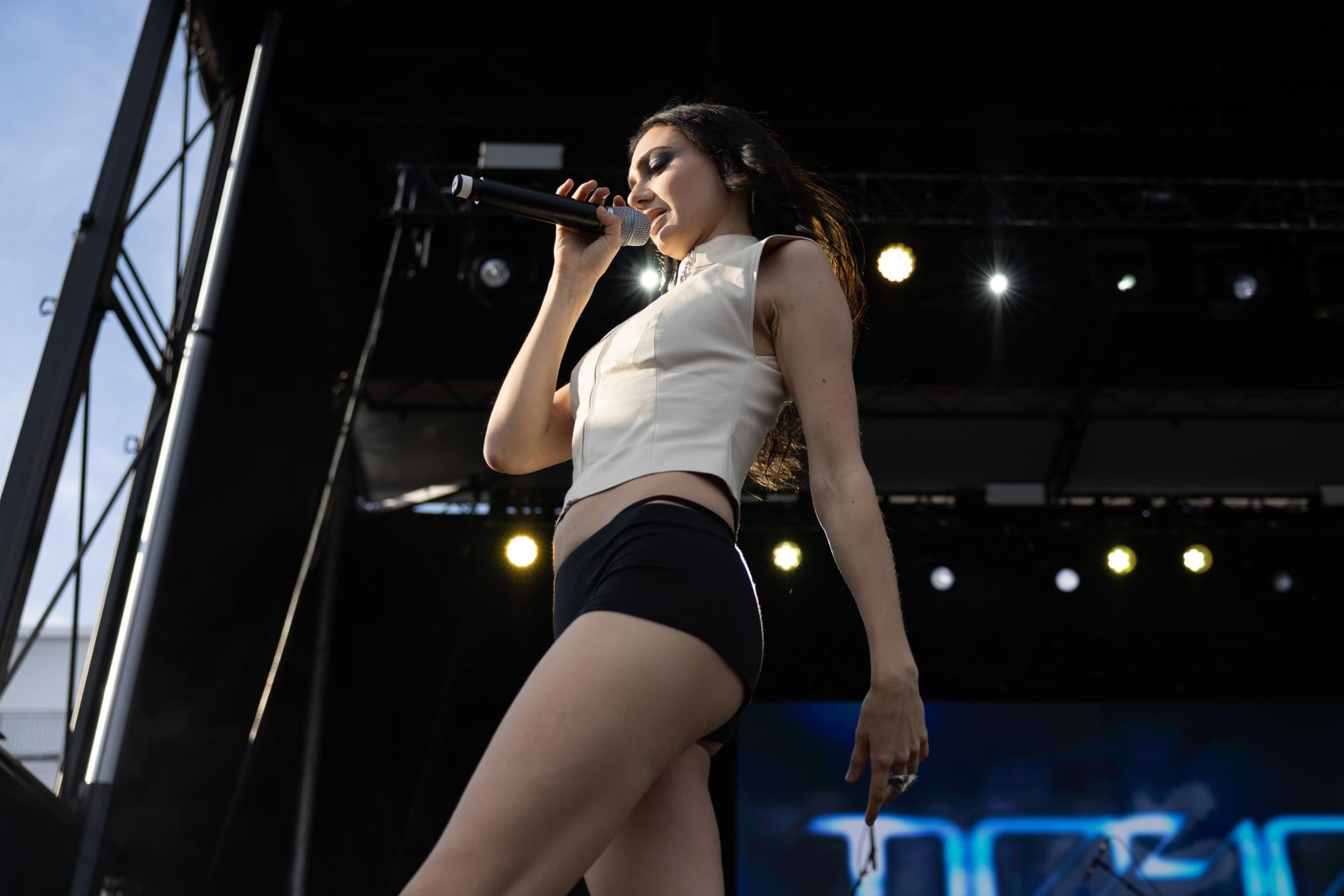 A person holding a microphone walks across a stage.
