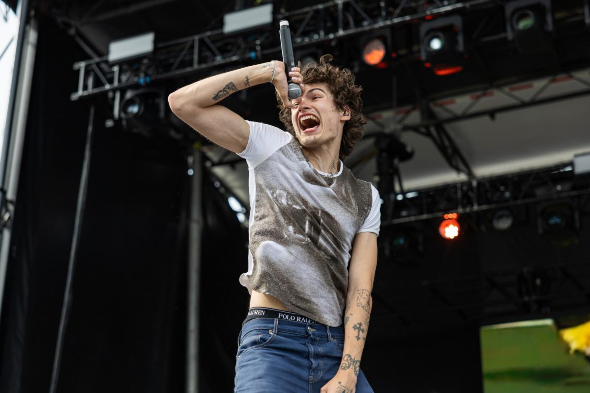 An artist jumps and yells into a microphone during their performance.