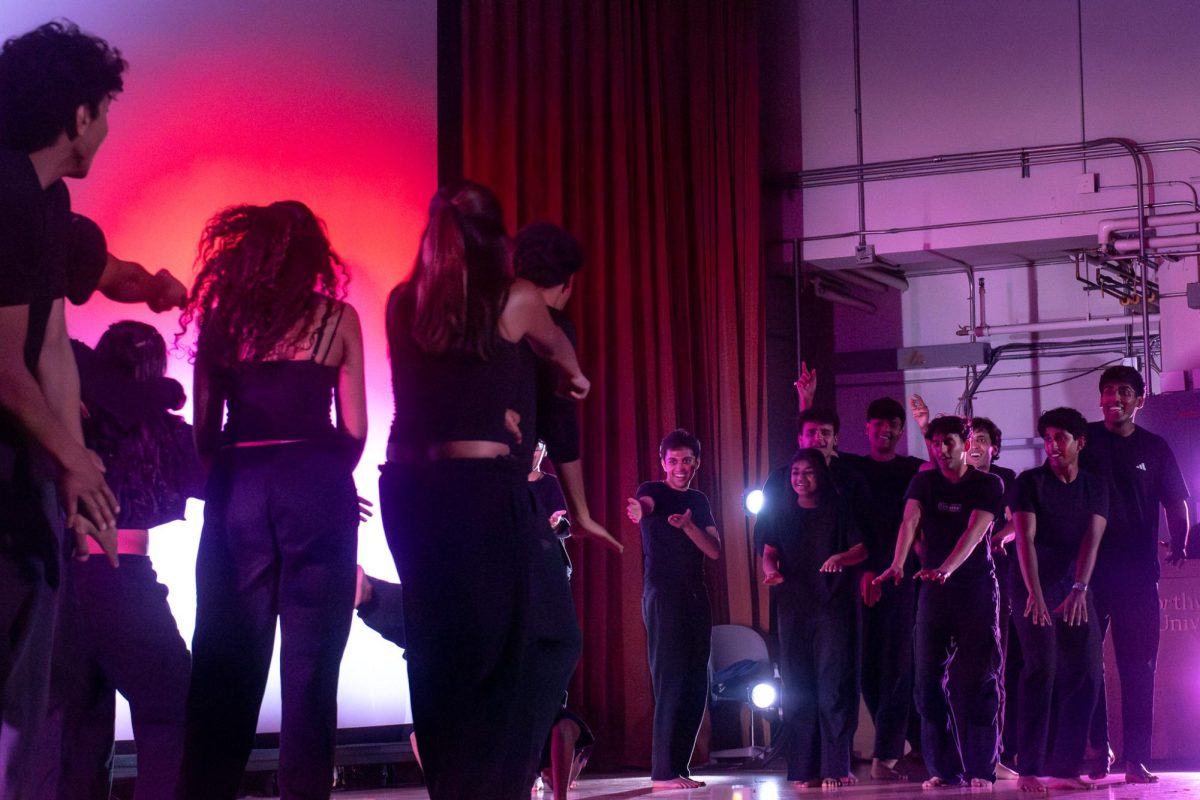 A solo performer took center stage as surrounding dancers pause.