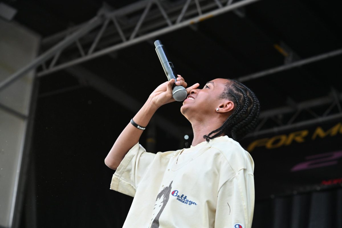 A performer tilts their head up and holds the microphone to their mouth. 