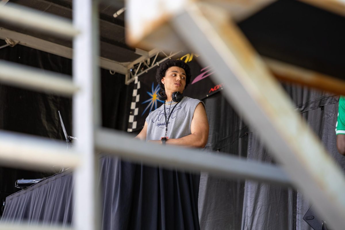 A performer glances to the side, framed by metal bars.