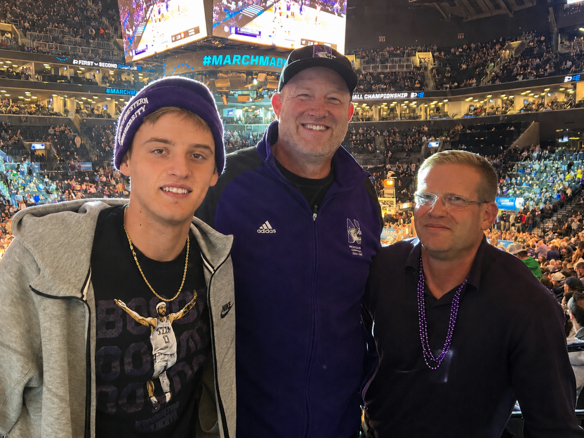 Three people pose at a stadium.