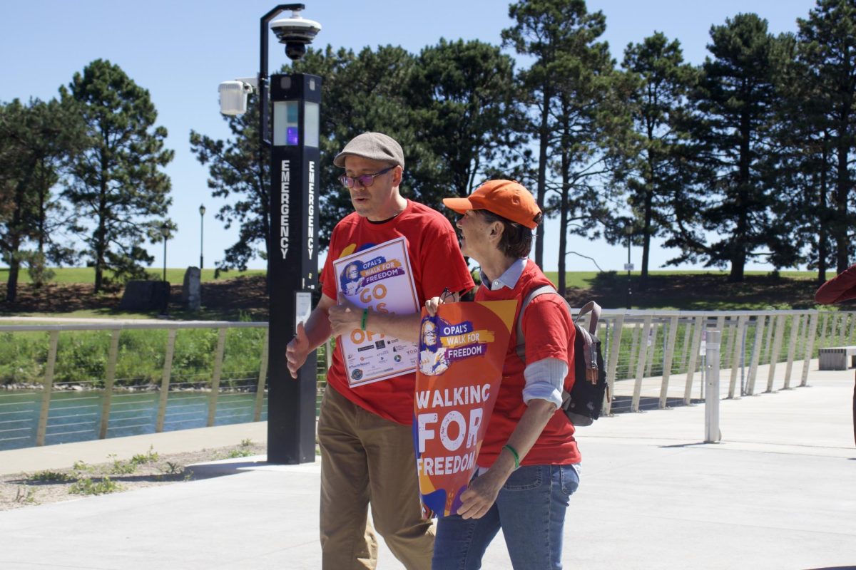 Two people talk as they walk in a parade.
