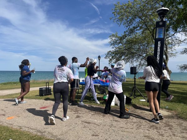 Students chase and spray each other with paint along the Lakefill