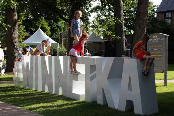 Children climb on a sign that says &ldquo;Winnetka.&rdquo;