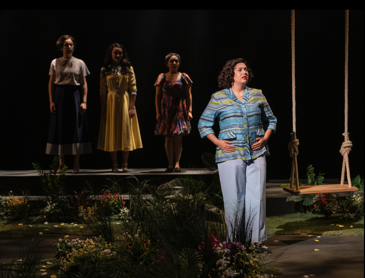 Four people stand center stage.
