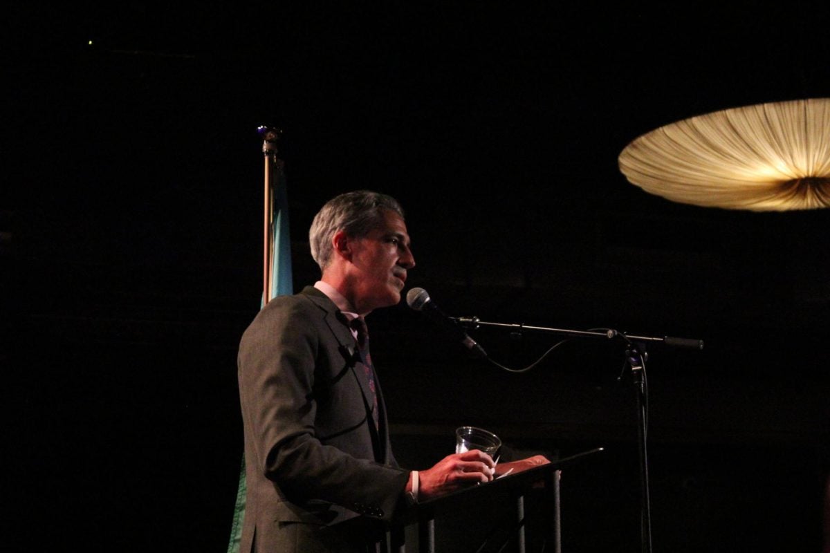 A person stands at a lectern.