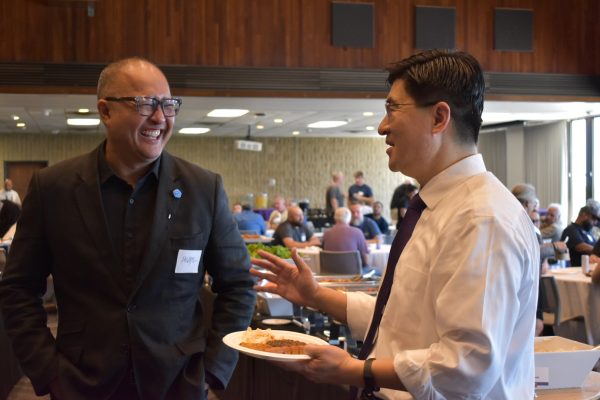 A person speaks to another at a dinner.